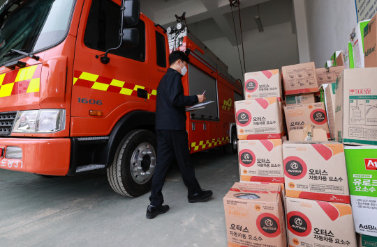 4일 서울 도봉구 서울소방재난본부 차량정비센터에서 소방 관계자가 서울 관내 소방서의 소방차와 구급 차량에 쓰이는 요소수 통합관리를 위해 모아둔 물량을 확인하고 있다.  연합뉴스